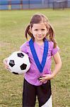 Portrait of girl football player with medal on practice pitch