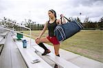 Soccer player placing sports bag on bench
