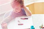 High angle view of boy sitting at table with art supplies