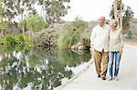 Senior couple walking beside lake