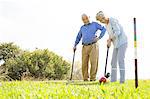 Senior couple playing croquet in park