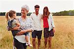 Multi-generation family walking in rural field