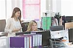 Fashion designers working at computer at desk in office