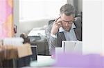 Focused businessman reviewing paperwork at desk in office