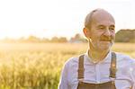 Close up senior farmer in sunny rural wheat field