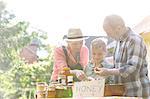 Grandparents and grandson selling honey at farmer's market stall