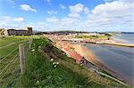 St. Mary's Church and churchyard with view across Tate Hill Beach and town houses to West Cliff, Whitby, North Yorkshire, England, United Kingdom, Europe