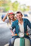 Happy couple on a scooter outdoors