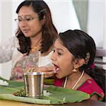 Indian family dining at home. Candid photo of India people eating rice with hands.