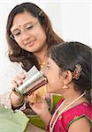 Indian family dining at home. Photo of child drinking water on dining table. Traditional home cook meal.