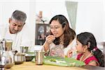 Indian family dining at home. Candid photo of India people eating rice with hands. Asian culture.