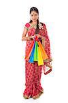 Indian girl in traditional sari shopping for diwali festival, full length standing isolated on white background.