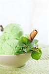 Scoop of mint ice cream in cup on wooden vintage background.