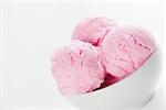 Close up scoops strawberry ice cream in bowl with copy space on side, white background.