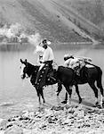 1920s 1930s MAN COWBOY ON HORSE WITH PACK HORSE BY MORAINE LAKE ALBERTA CANADA