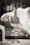 A woman mixing a cocktail, a mixologist at work.