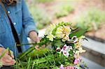 A woman holding a bunch of summer garden flowers.