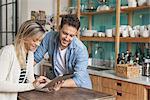 Couple using digital tablet in kitchen