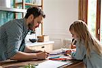 Father and daughter drawing at home