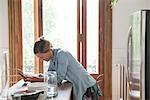 Young woman using smartphone in kitchen