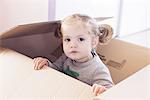 Little girl playing in cardboard box, portrait