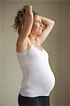 Pregnant woman with hands in hair looking away