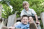 Three friends having fun on slide in playground, Munich, Bavaria, Germany