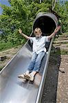 Boy sliding on slide in playground, Munich, Bavaria, Germany