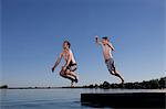 Father and son jumping into lake