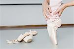 Ballet dancer examining toes on pointe