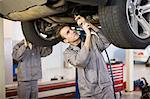 Mechanic working on car engine in garage