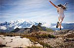 Girl jumping in rocky landscape