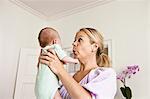 Mother holding infant in bedroom