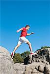 Rock climber jumping between rocks