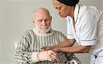 Caretaker wrapping older man's wrist