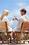 Couple toasting each other outdoors