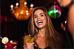 Smiling couple having cocktails in club