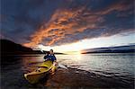 Woman kayaking in still lake