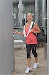 Smiling older woman carrying gym bag