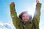 Girl cheering on snowy mountaintop