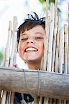 Close up of boy smiling behind fence