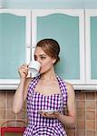 Woman having cup of coffee in kitchen