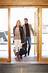 Couple walking through hotel front doors