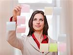 Businesswoman hanging up sticky notes