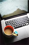 Coffee Mug on Laptop Computer with Beach on Screen