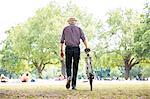 Senior man with bicycle in park, Hackney, London