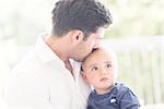 Father kissing young son on head