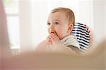 Baby boy feeding himself in baby chair