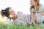 Mature woman and daughter laughing and playing in park