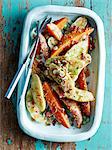 Overhead view of roasted vegetable dish with mustard seeds on rustic table